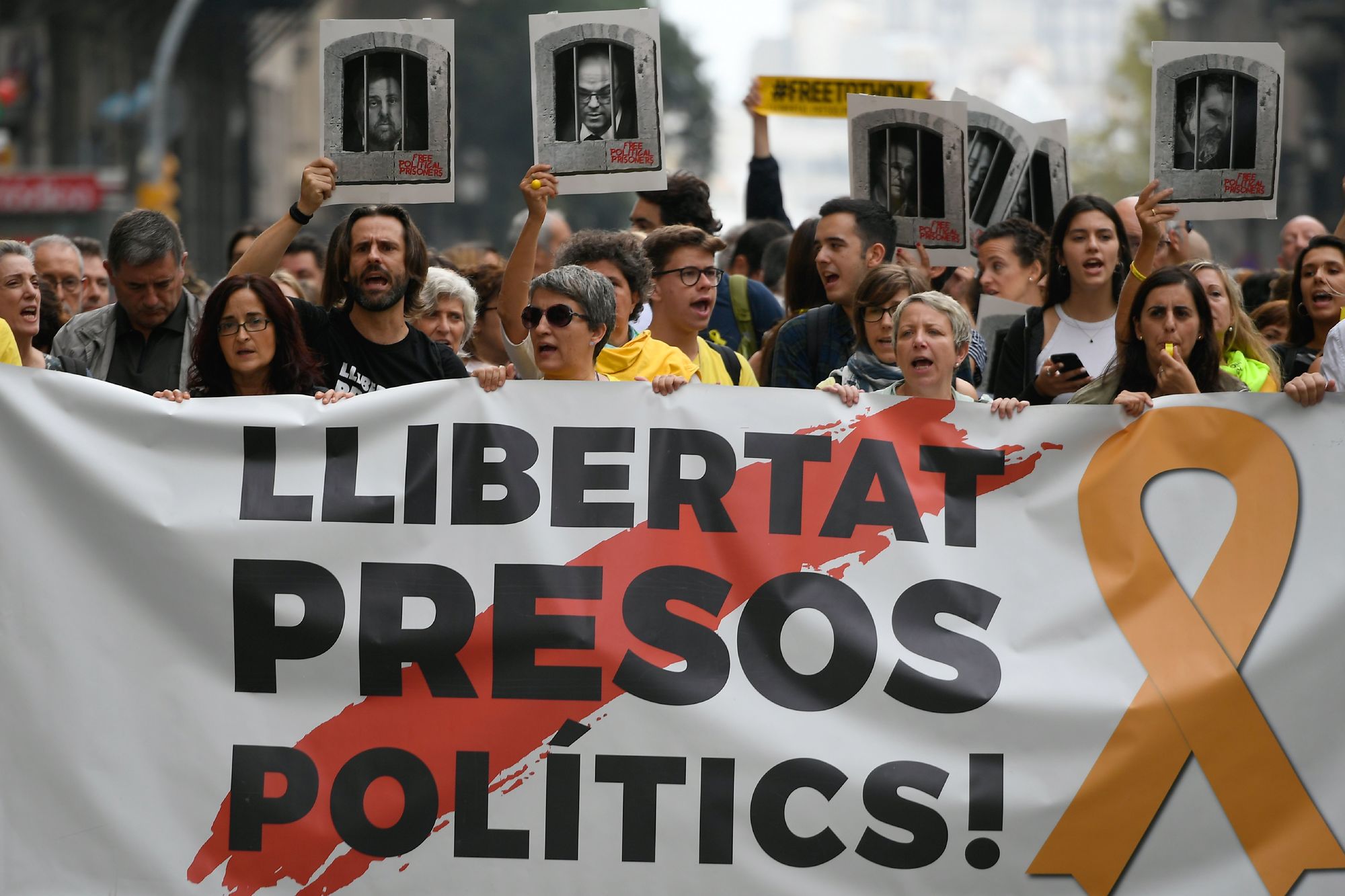 Protestors holding a banner reading "Free political prisoners" Credit: LLUIS GENE / Getty Images