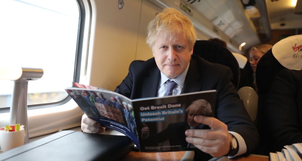 Boris Johnson holds a copy of the Conservative manifesto. Credit: Getty