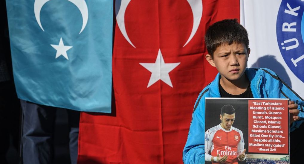 A supporter of China's Muslim Uighur minority holds a placard of Arsenal's Mesut Ozil during a demonstration at Beyazid square in Istanbul. Credit: Getty