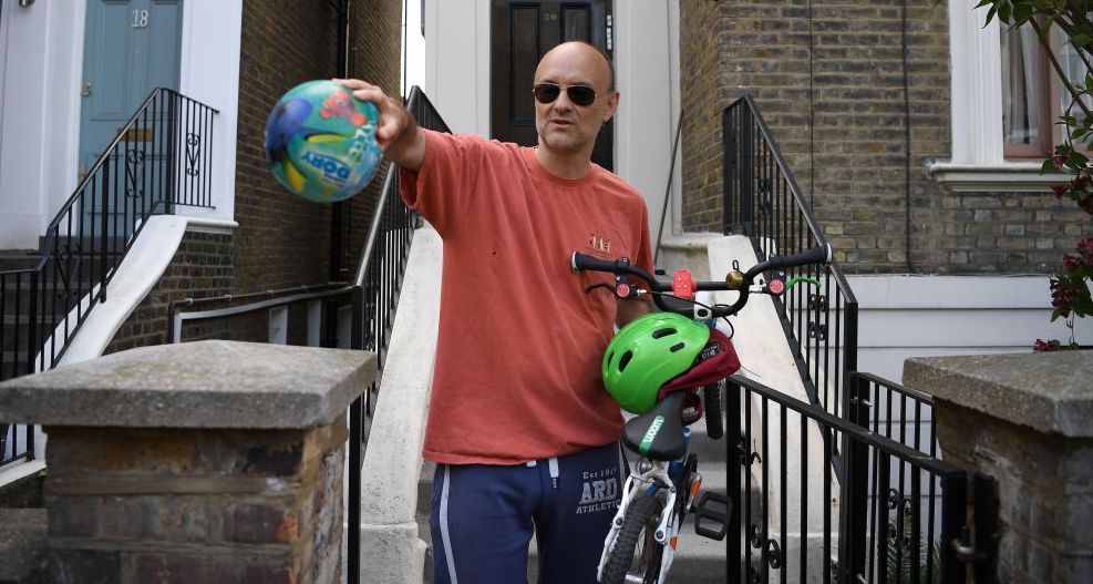 Dominic Cummings gestures to members of the media to observe social distancing guidelines outside his home in London. Credit: Getty