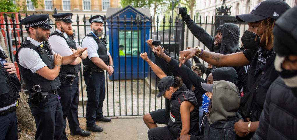 People kneel in front of police during a Black Lives Matter protest at Hyde Park. (Photo by Justin Setterfield/Getty Images)