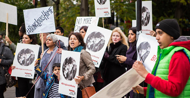 Afsana Lachaux (centre, in blue scarf) joins her supporters chanting "bring Louis home" in 2015
