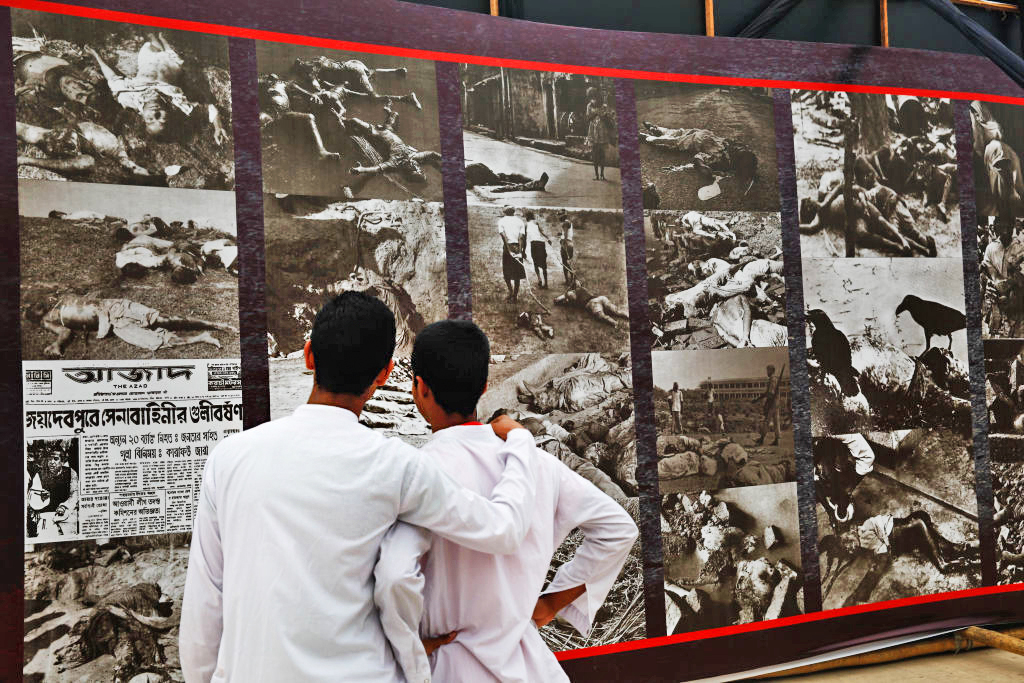 Two boys observing a photo exhibition which remembers Bangladesh Independence day. Credit: Getty
