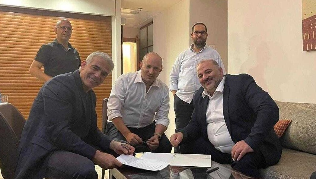 Yesh Atid leader Yair Lapid (L), Yamina leader Naftali Bennett (C) and Ra'am leader Mansour Abbas sign a coalition agreement on June 2, 2021