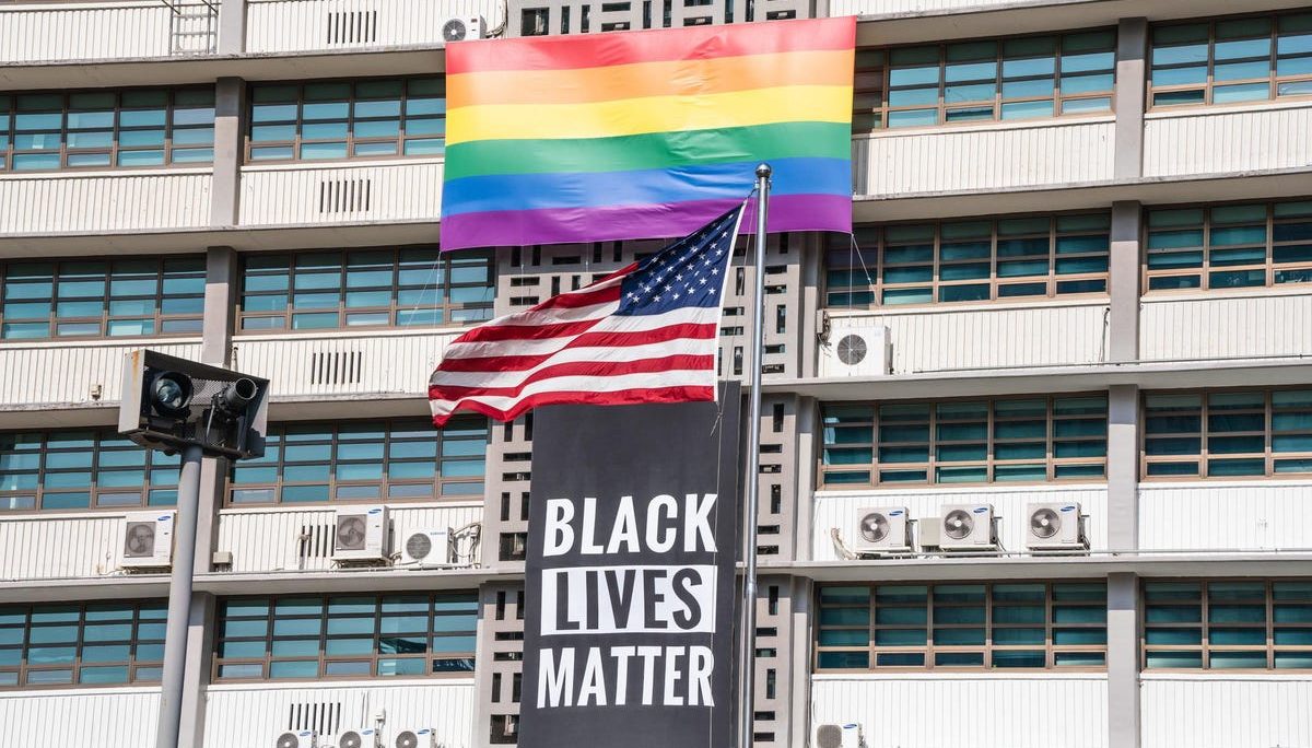 A BLM banner, a US national flag and a LGBT flag outside the US embassy in Seoul, South Korea