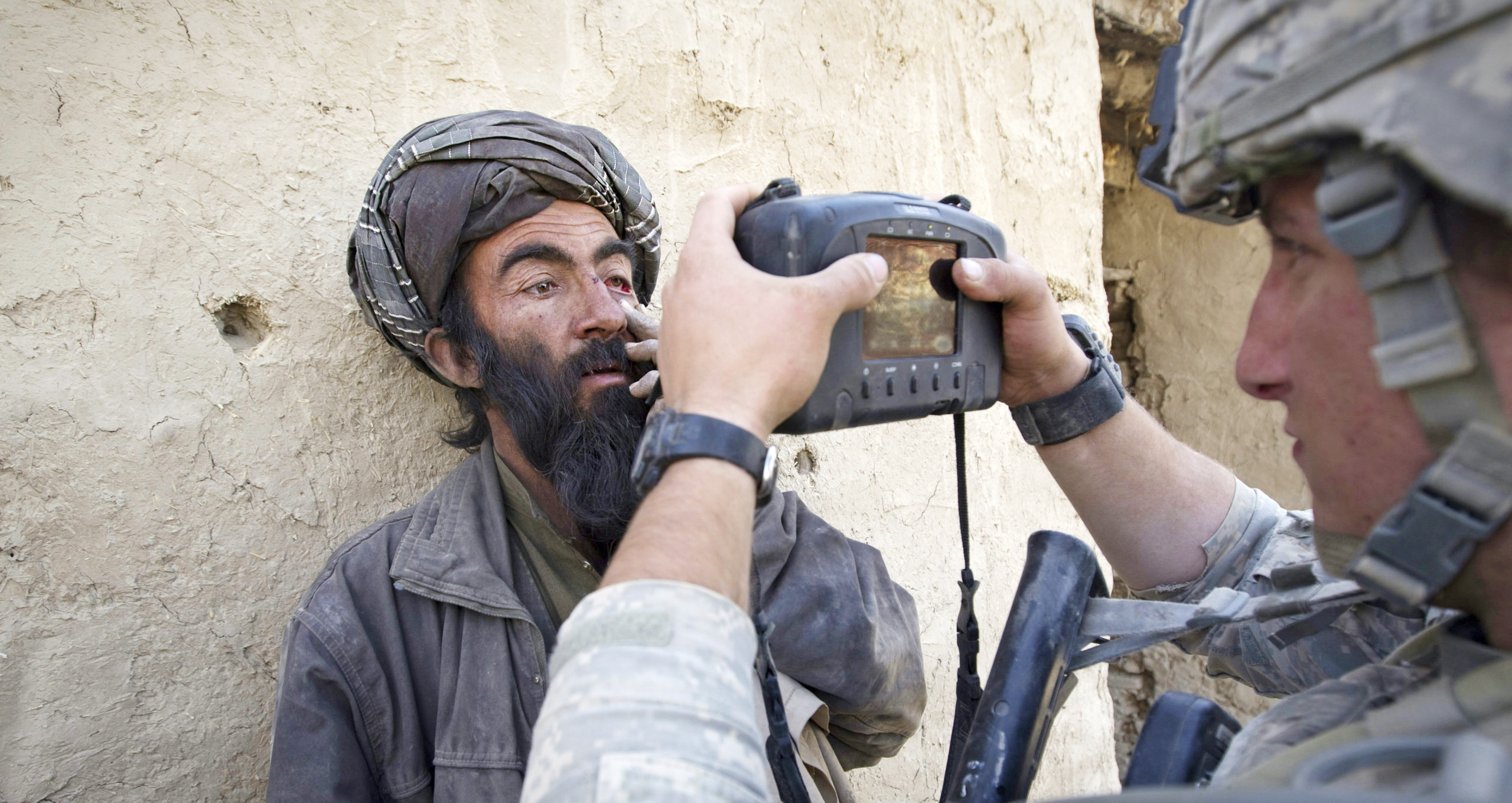 A US soldier takes a biometric scan of an Afghan villager in 2010. Credit: Getty