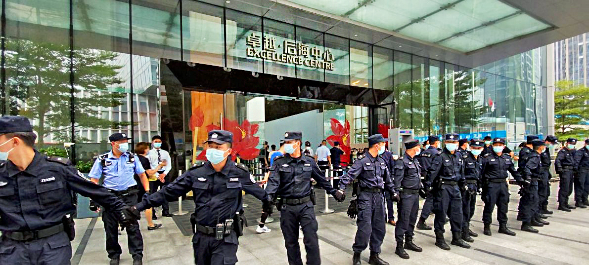 Police stand outside an Evergrande building