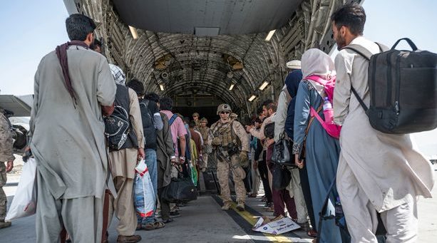 Afghans board a plane for the UK in Kabul