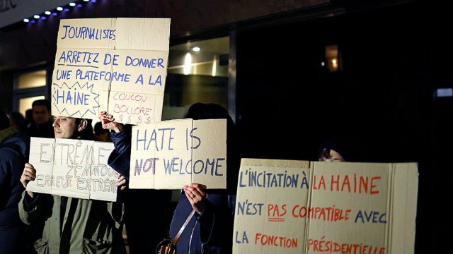 Protesters hold up placards ahead of the arrival of Éric Zemmour in London.