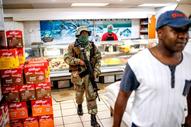 A South African soldier searches for people not wearing face masks (MICHELE SPATARI/AFP via Getty Images)