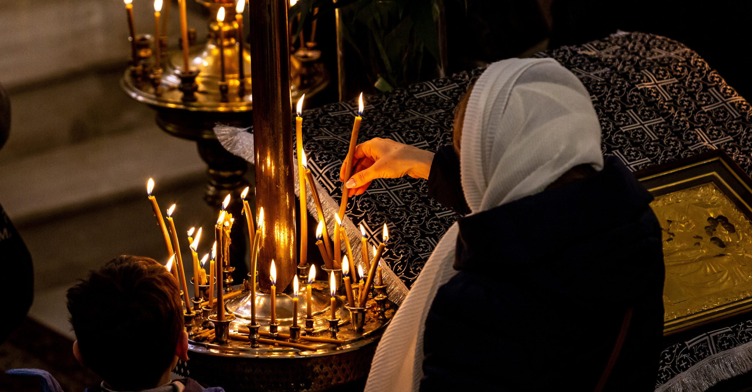 A woman lights candles during a Holy Mass in Krakow, Poland. Credit: Getty