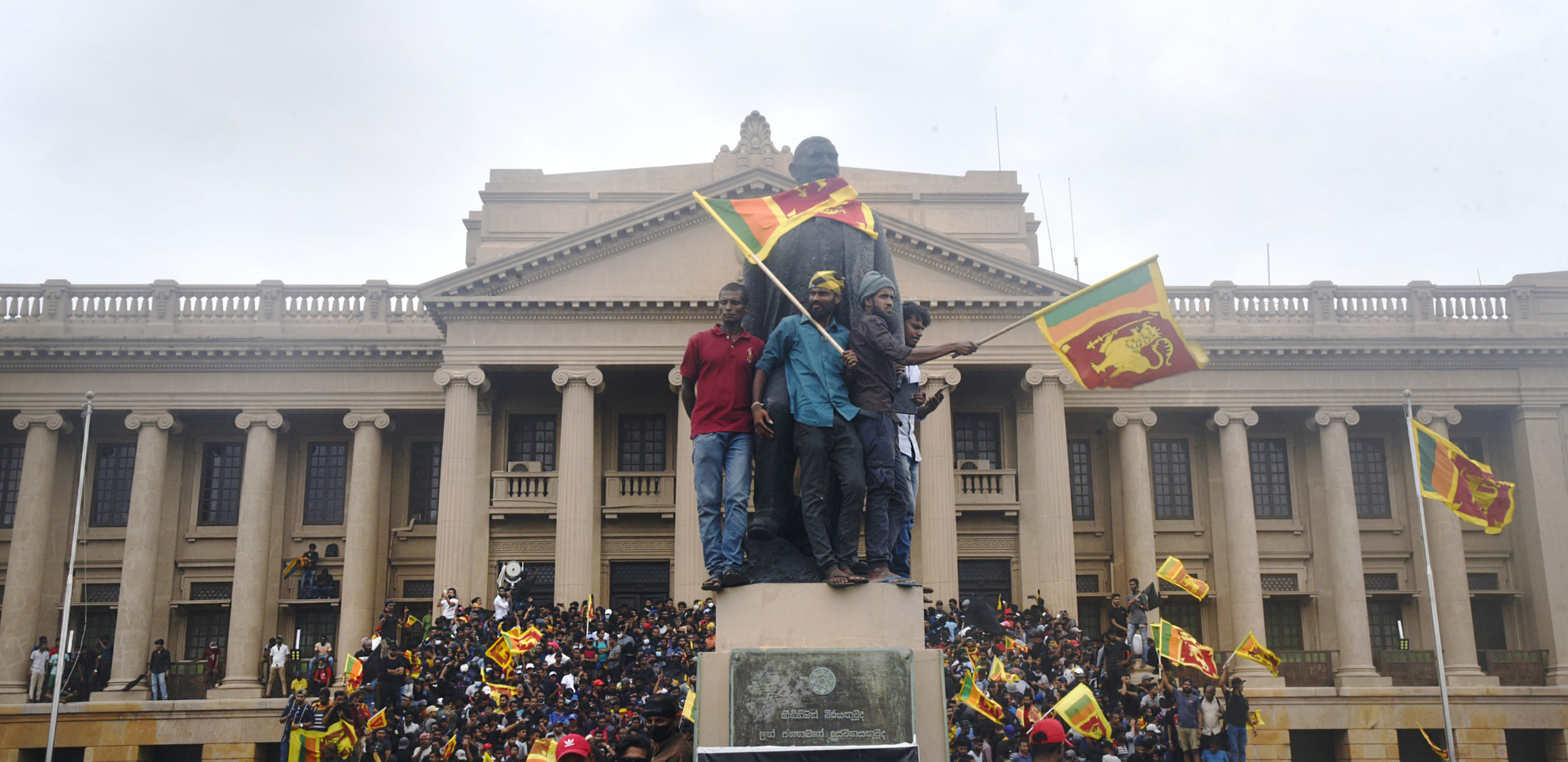 Protesters on top statues at Presidential Secretariat in Colombo. Credit: Getty