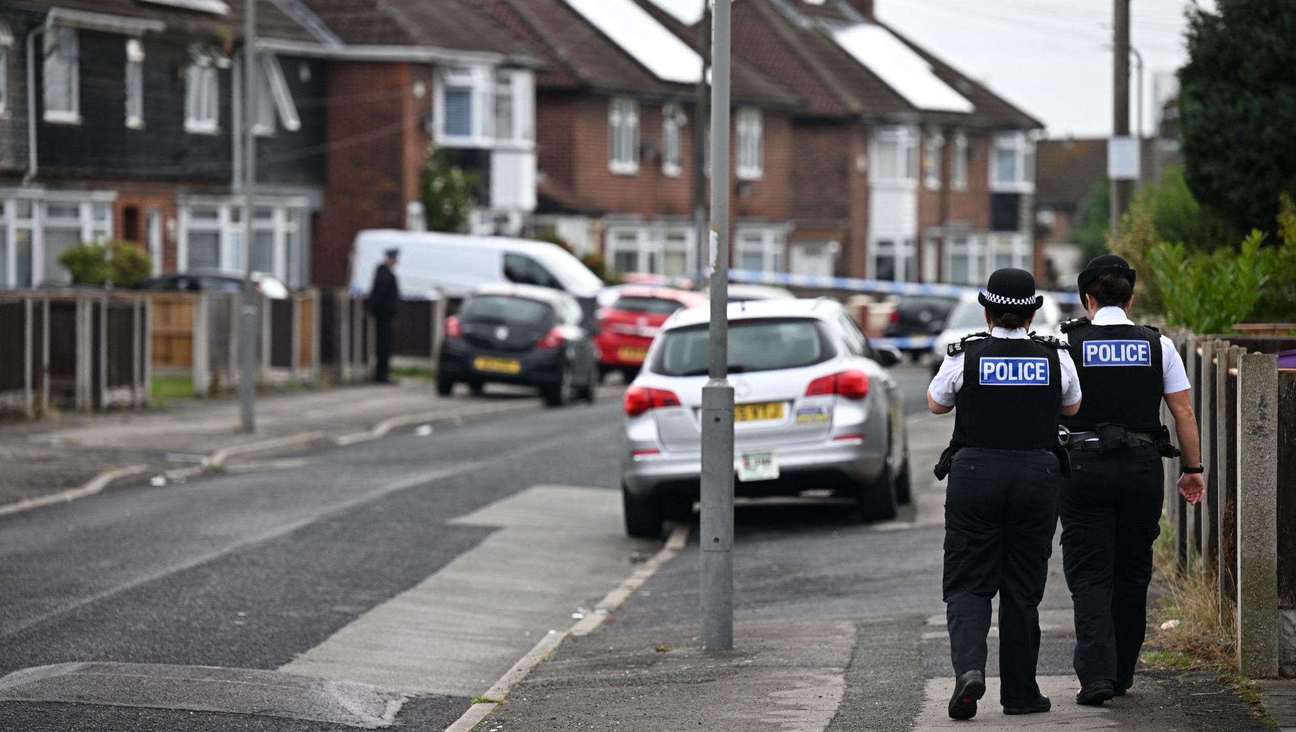 British Police officers walk behind a security cordon by a house in the Knotty Ash area in Liverpool, on August 23, 2022, where a 9 years old girl was shot overnight by a gunman. (Photo by Paul ELLIS / AFP) (Photo by PAUL ELLIS/AFP via Getty Images)