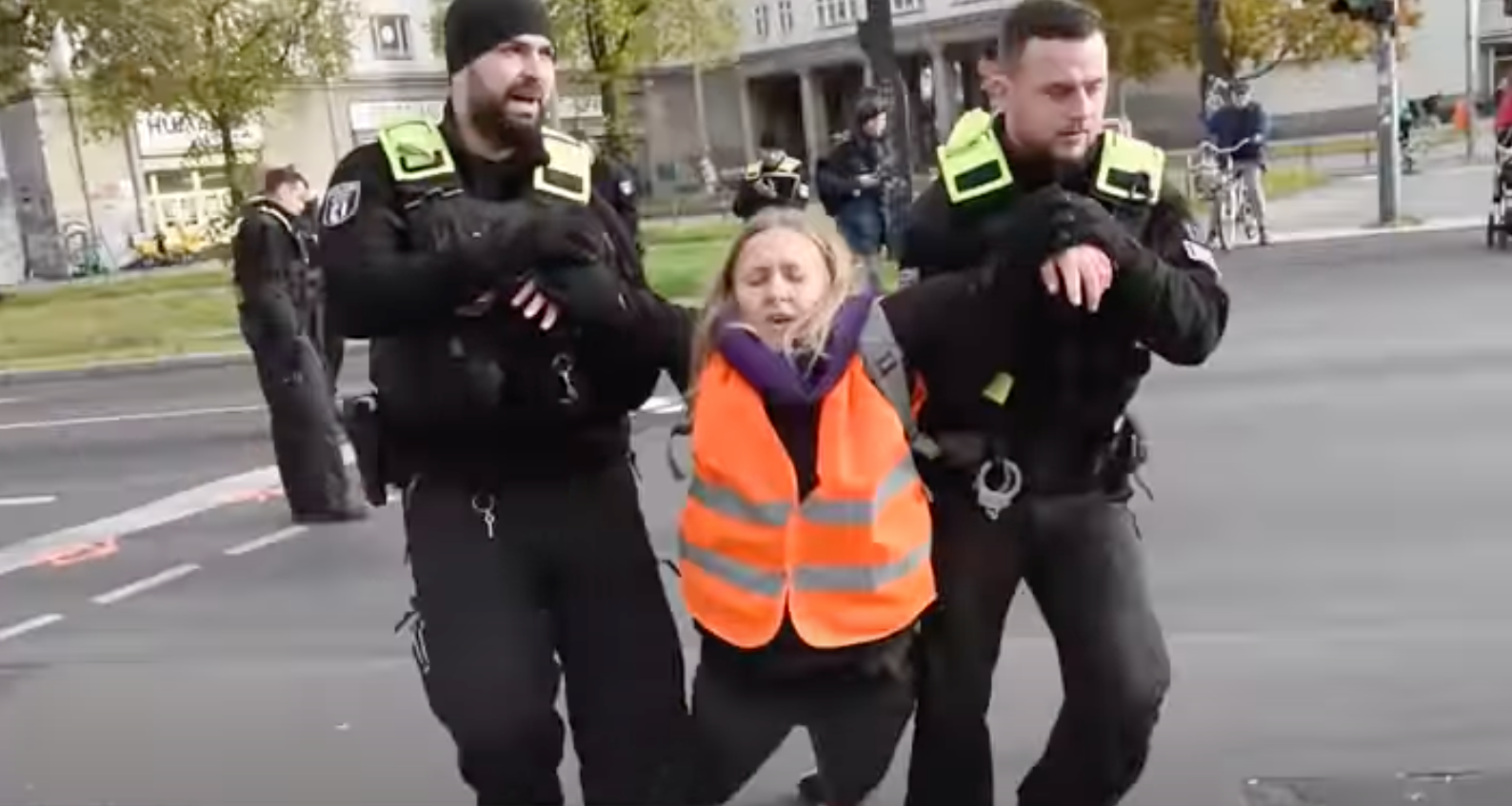 A climate protestor is escorted away by German police.