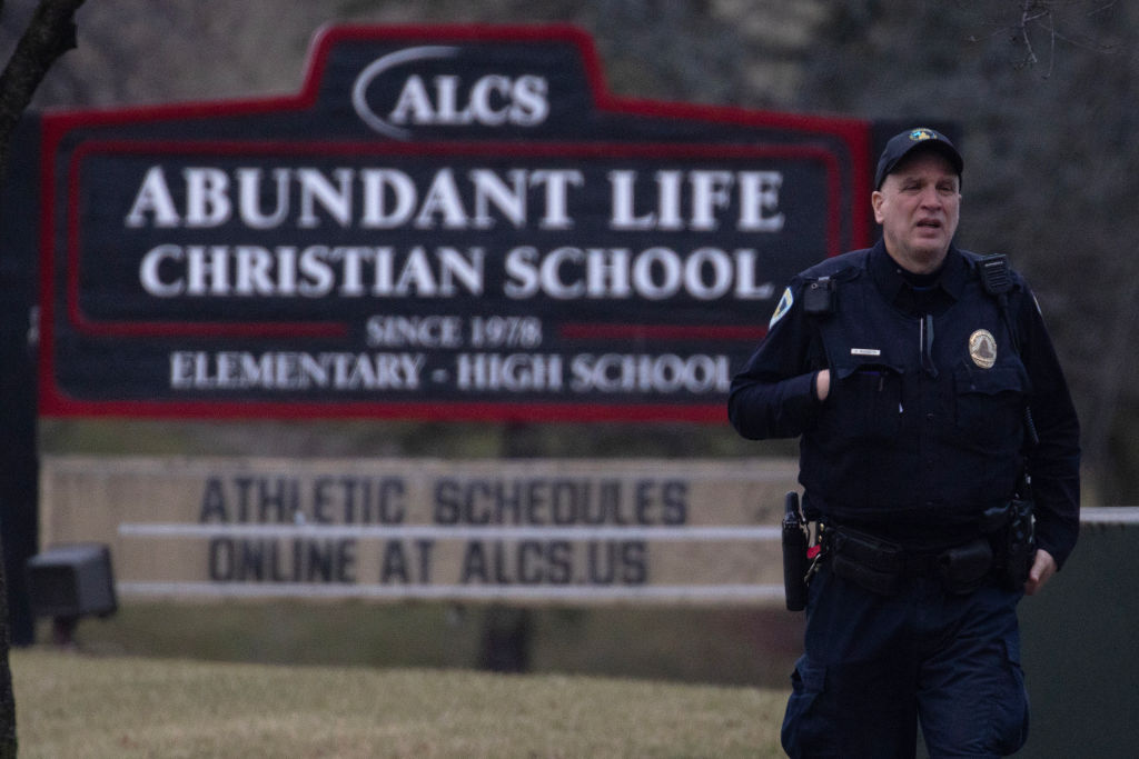 A police officer stands guard in front of Abundant Life Christian School in Madison, Wisconsin on Monday after a student shot two people dead. Credit: Getty
