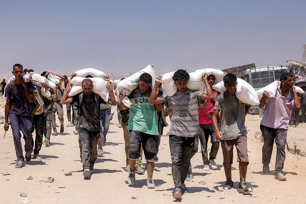 Palestinians carry sacks of flour into northern Gaza this month. Credit: Getty