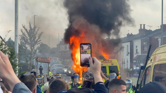 A police van erupts in flames during violent disorder in Southport. Photograph: Ben Roberts-Haslam